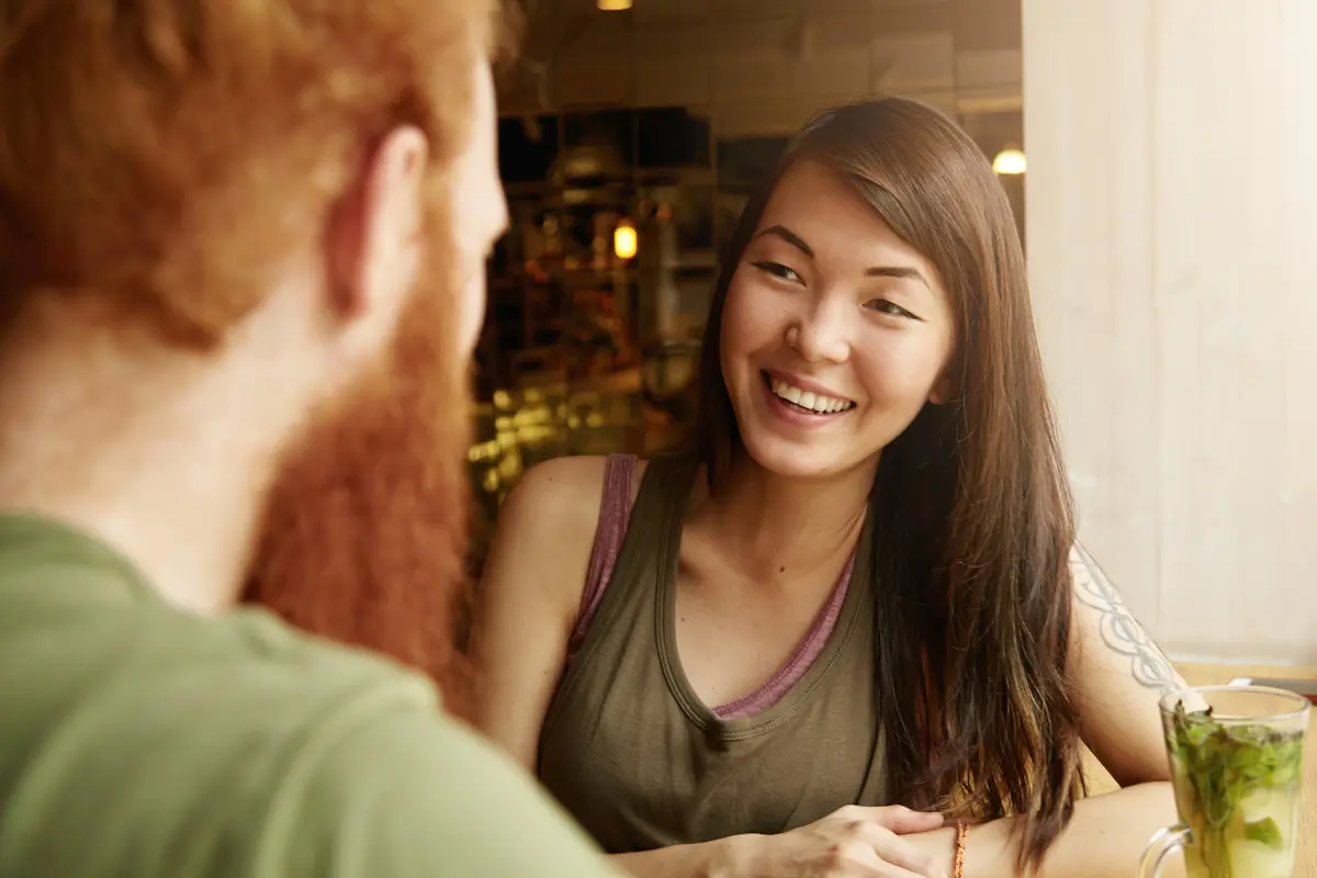 Woman smiling at person in a cafe.