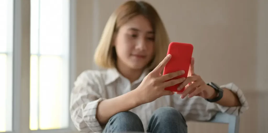 Woman using smartphone indoors.