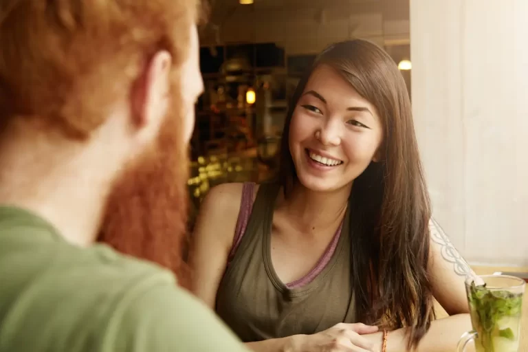 Frau lächelt Person in einem Café an.