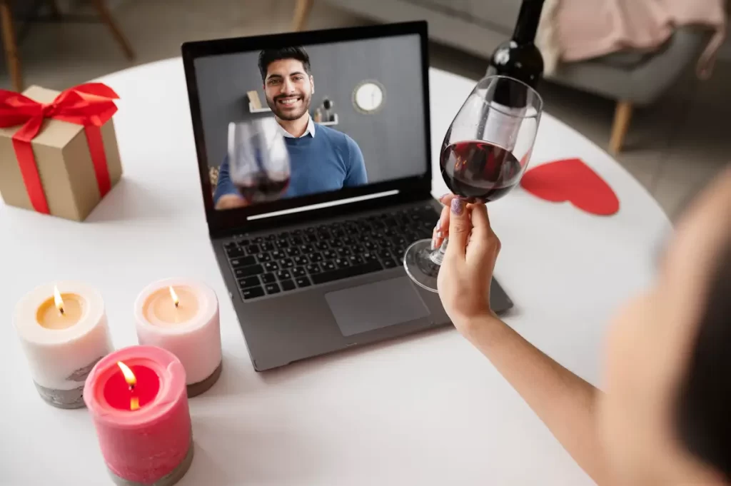 Virtual wine toast during video call celebration.