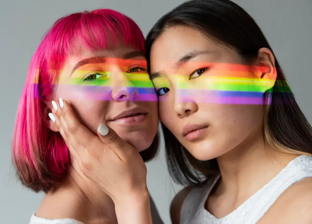 asian ladyboy and westeren transgender with rainbow light across faces