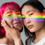 asiatischer ladyboy und westeren transgender mit regenbogenlicht im gesicht